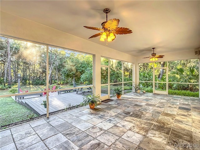 unfurnished sunroom with ceiling fan and a healthy amount of sunlight