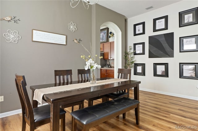 dining room with light hardwood / wood-style floors and an inviting chandelier