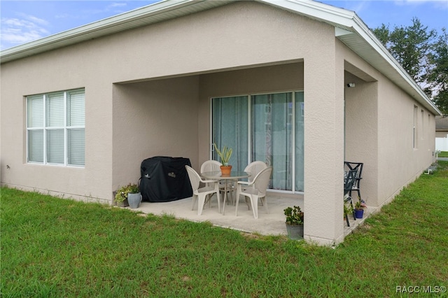 rear view of house featuring a lawn and a patio area