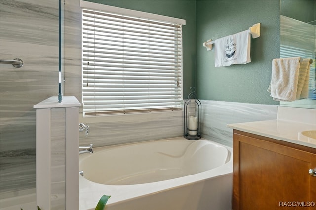 bathroom with a washtub and vanity