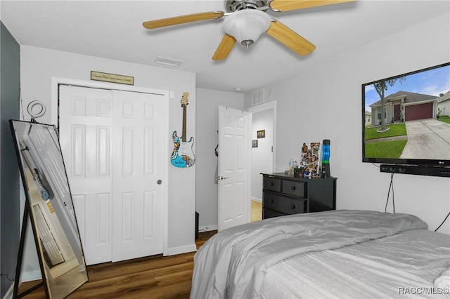 bedroom with ceiling fan, dark hardwood / wood-style floors, and a closet