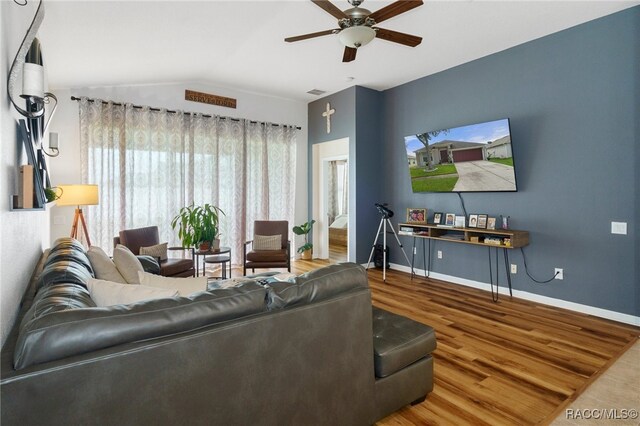 living room featuring hardwood / wood-style flooring, ceiling fan, and lofted ceiling