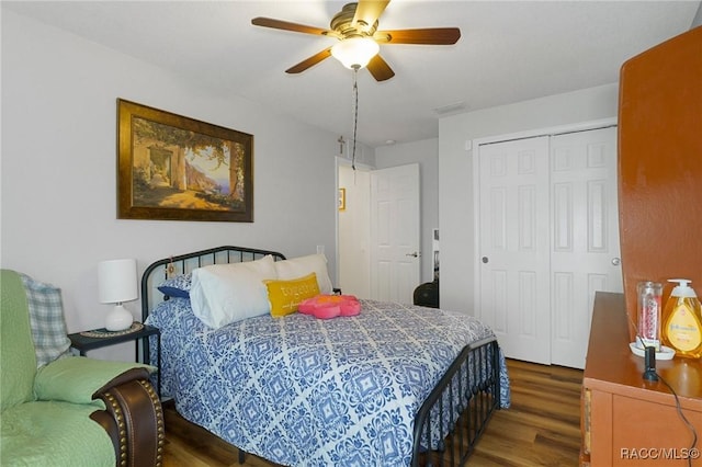 bedroom featuring ceiling fan, dark hardwood / wood-style floors, and a closet