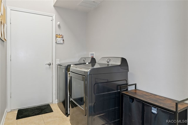 washroom featuring washing machine and dryer and light tile patterned flooring