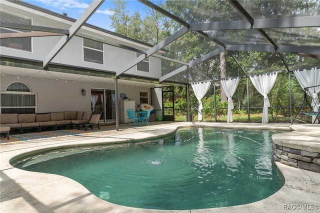 view of swimming pool featuring an outdoor hangout area, glass enclosure, and a patio area