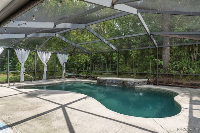 view of swimming pool featuring pool water feature, glass enclosure, and a patio