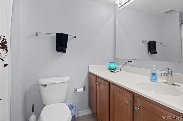 bathroom with vanity, a textured ceiling, and toilet