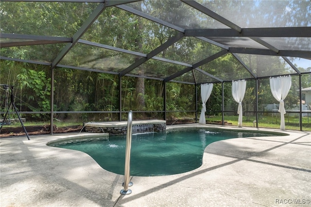 view of swimming pool with pool water feature, glass enclosure, and a patio area