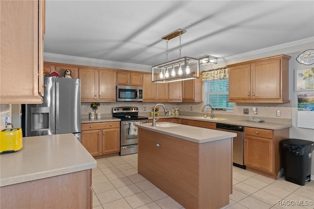 kitchen with appliances with stainless steel finishes, a center island with sink, decorative light fixtures, and ornamental molding