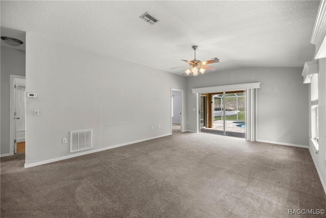 carpeted empty room with a ceiling fan, a textured ceiling, visible vents, and lofted ceiling