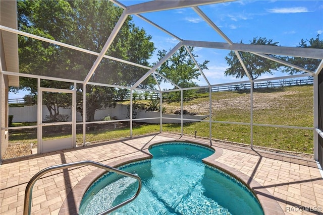 view of pool featuring a patio, a fenced backyard, glass enclosure, and a fenced in pool