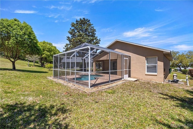 rear view of house with a lanai, a lawn, an outdoor pool, a patio area, and stucco siding