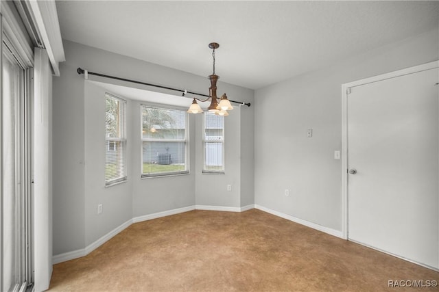 empty room with an inviting chandelier, baseboards, and light carpet
