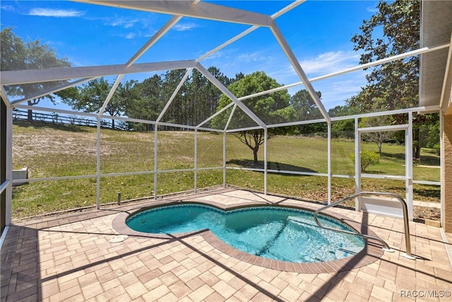 outdoor pool featuring a patio area, a lanai, and a yard