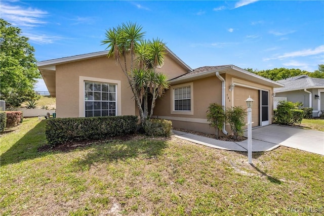 single story home with a garage, stucco siding, a front yard, and concrete driveway