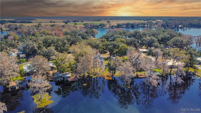 aerial view at dusk featuring a water view