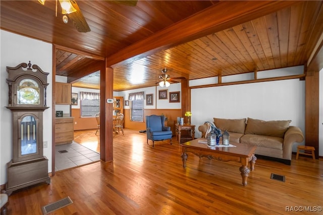 living room featuring beam ceiling, light wood-type flooring, and ceiling fan