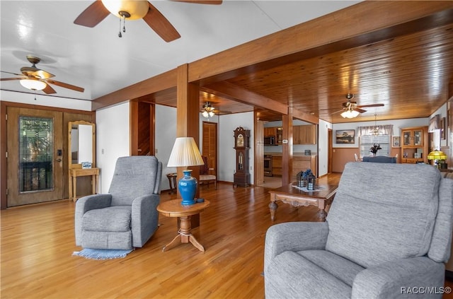 living room featuring hardwood / wood-style flooring, ceiling fan with notable chandelier, and wood ceiling