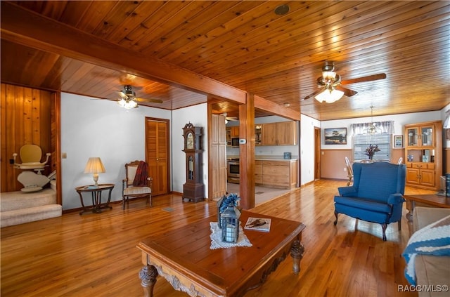 living room featuring wood ceiling, ceiling fan, beam ceiling, and light hardwood / wood-style floors