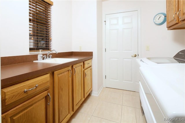 clothes washing area with light tile patterned flooring, cabinets, separate washer and dryer, and sink