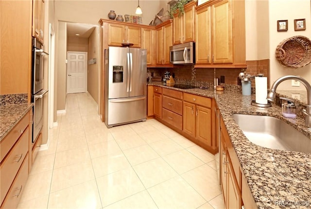 kitchen with decorative backsplash, sink, light tile patterned floors, and stainless steel appliances