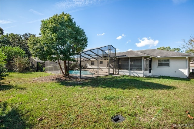 view of yard featuring a fenced in pool and glass enclosure