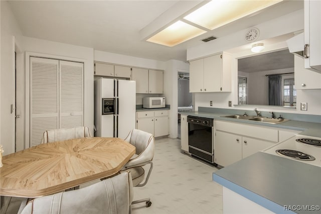 kitchen with sink, white cabinets, and white appliances