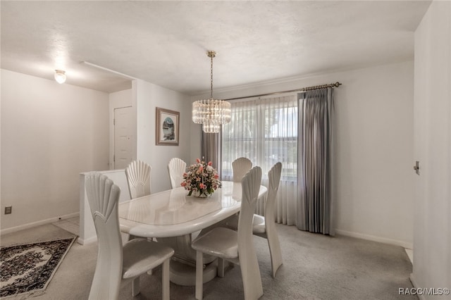 dining area featuring light carpet and a chandelier