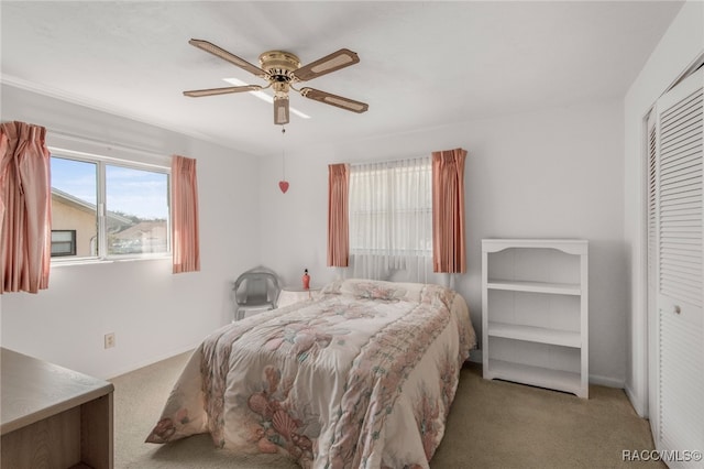 bedroom featuring ceiling fan, a closet, and light carpet