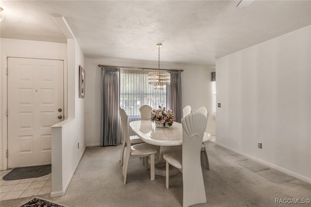 carpeted dining area featuring a chandelier