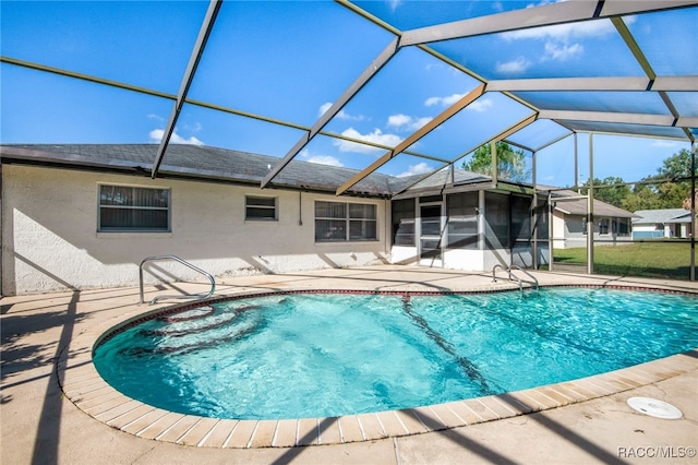 view of swimming pool featuring glass enclosure and a patio area