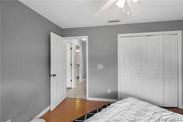 bedroom featuring ceiling fan, a closet, and light hardwood / wood-style flooring