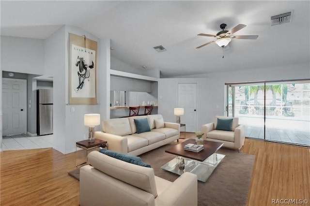 living room featuring ceiling fan, light hardwood / wood-style flooring, and lofted ceiling