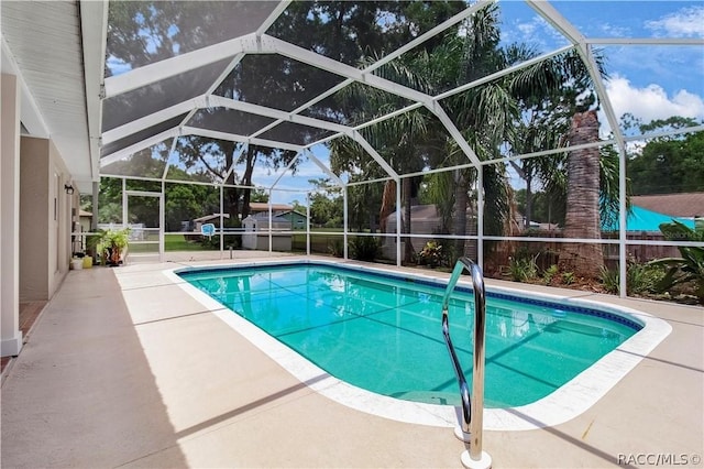 view of swimming pool with glass enclosure and a patio area