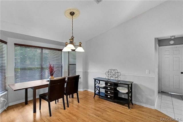 dining space featuring tile patterned floors and lofted ceiling