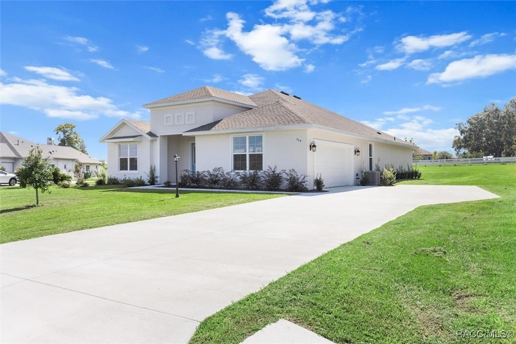 view of front of property featuring cooling unit, a garage, and a front lawn