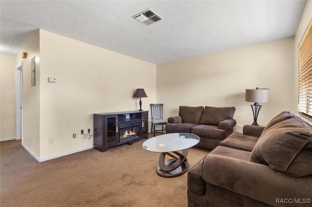 living room with a textured ceiling, carpet floors, and a fireplace