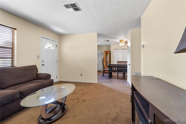 living room with carpet, a textured ceiling, and ceiling fan