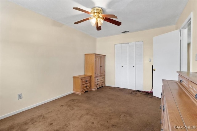 unfurnished bedroom featuring dark colored carpet, ceiling fan, and a closet