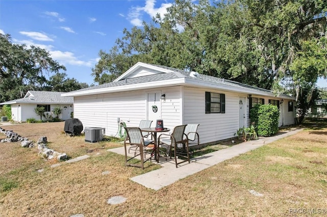 back of house with a yard, central AC unit, and a patio area