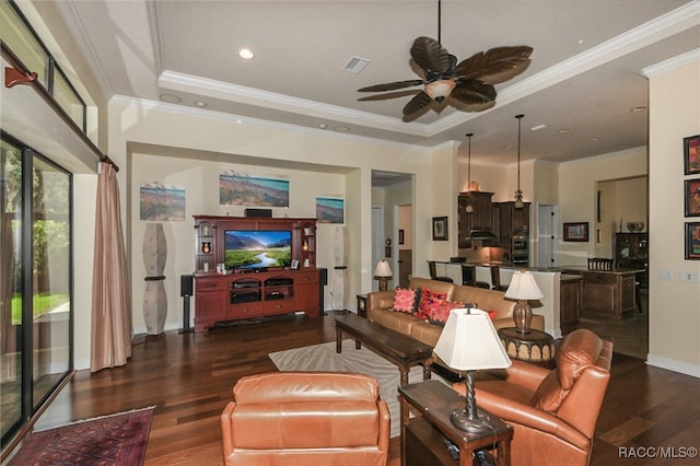 living room with dark hardwood / wood-style floors, a raised ceiling, ceiling fan, and crown molding