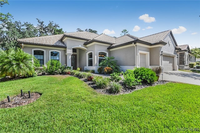 mediterranean / spanish-style home with a garage and a front yard