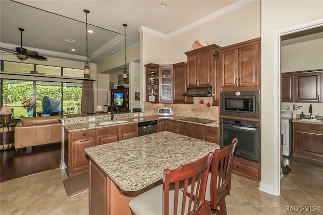 kitchen featuring kitchen peninsula, a kitchen breakfast bar, stainless steel appliances, sink, and hanging light fixtures