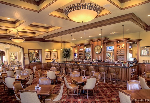 dining area with crown molding, beamed ceiling, indoor bar, and coffered ceiling