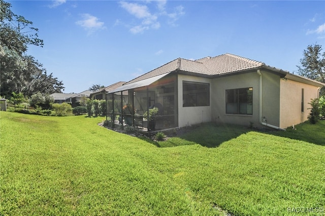 back of property with a sunroom and a yard