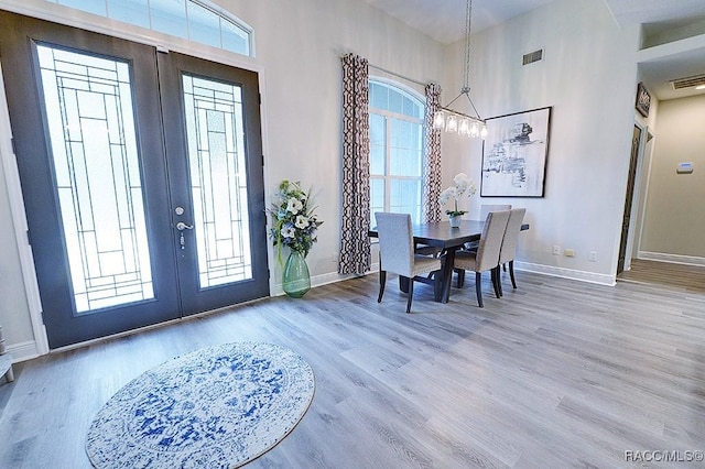 entrance foyer featuring visible vents, wood finished floors, and french doors