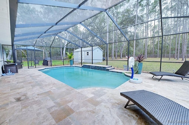 pool featuring a lawn, glass enclosure, a patio area, fence, and an outdoor structure