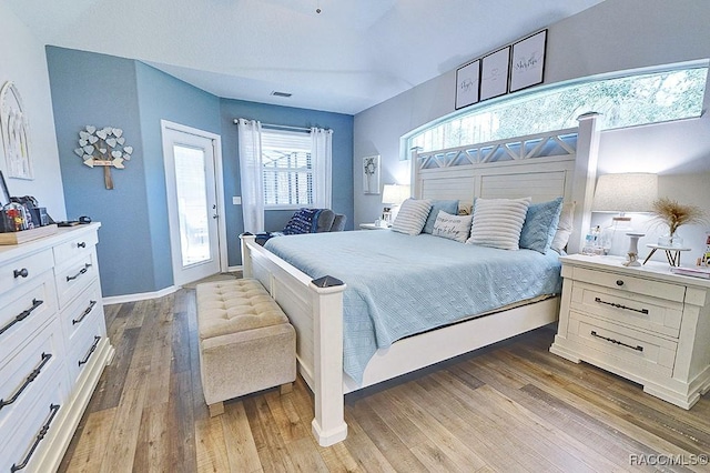 bedroom featuring access to exterior, light wood-style flooring, visible vents, and baseboards