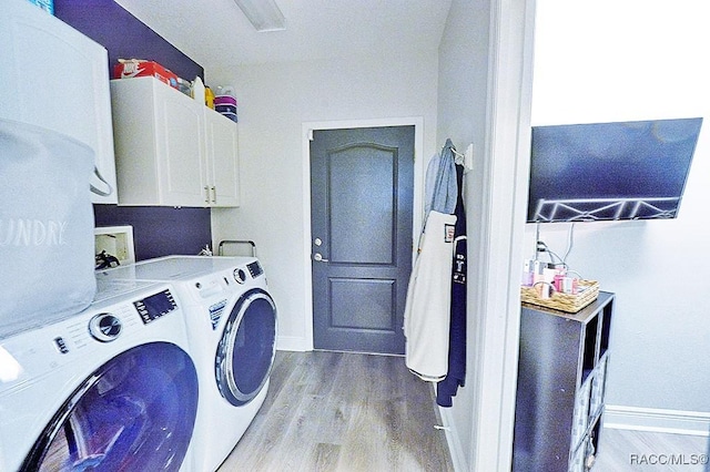 washroom featuring washer and clothes dryer, wood finished floors, cabinet space, and baseboards