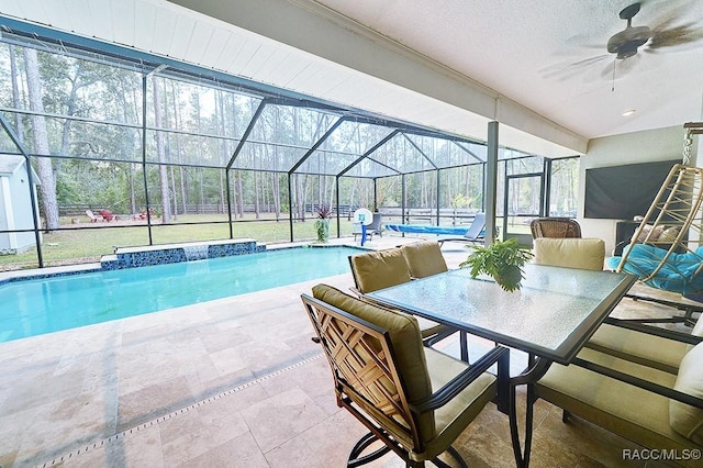 pool featuring ceiling fan, glass enclosure, outdoor dining area, and a patio area